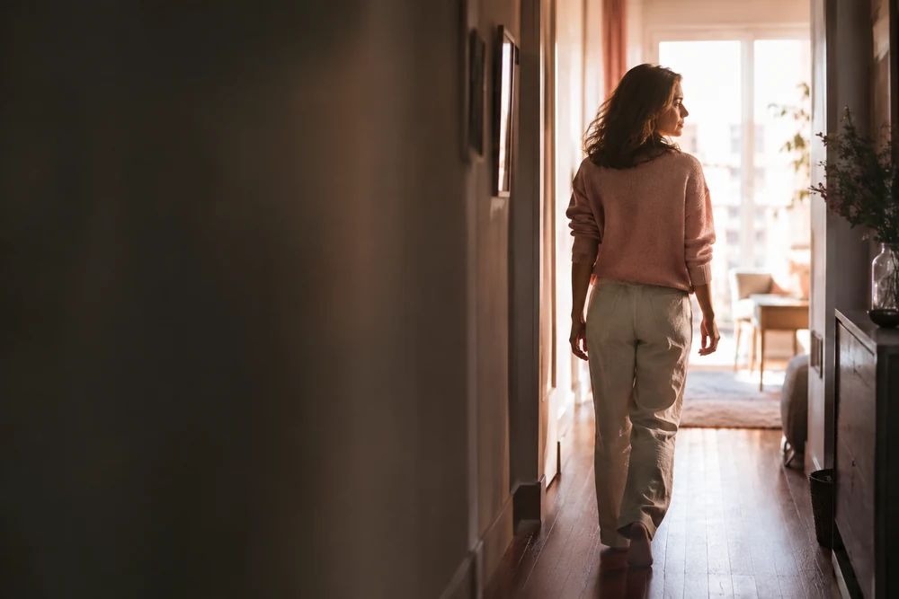 Sortir d'une relation toxique : une femme marche vers la lumière au bout d'un couloir, pas décidé